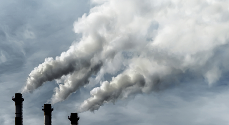 Giftiga utsläpp av giftiga gaser till atmosfären, industriell luftförorening. Miljöproblem och ekologi. Mörka skorstenar som blåser enorma rökvågar mot himlen